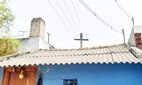 வீட்டிற்குள் நடுவே அமைந்துள்ள மின் கம்பம்.