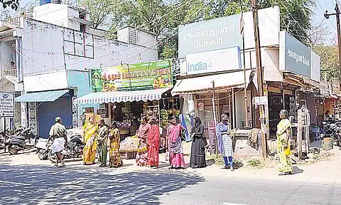 சாலை ஓரம் நின்று பேருந்துக்காக காத்துருந்த பொது மக்களை படத்தில் காணலாம்.