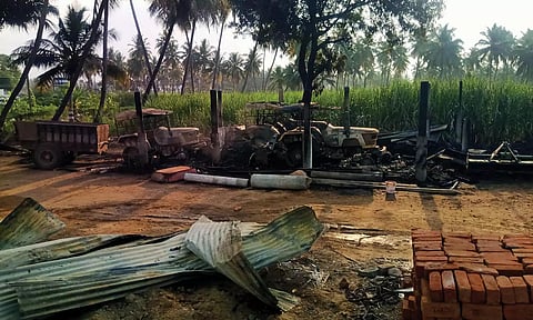 மர்ம நபர்கள் தீவைத்ததில் டிராக்டர்கள் கருகி கிடக்கும் காட்சி.