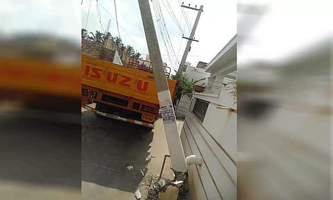 சாய்ந்து விழும் நிலையில் உள்ள மின் கம்பத்தை படத்தில் காணலாம்.