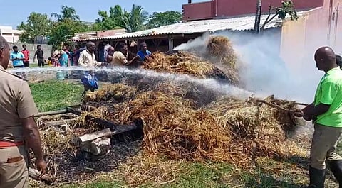 வைக்கோல் போரில் பற்றி எரிந்த தீயை தண்ணீரை பீய்ச்சி தீயணைப்பு வீரர்கள் அணைத்த போது எடுத்தபடம்.