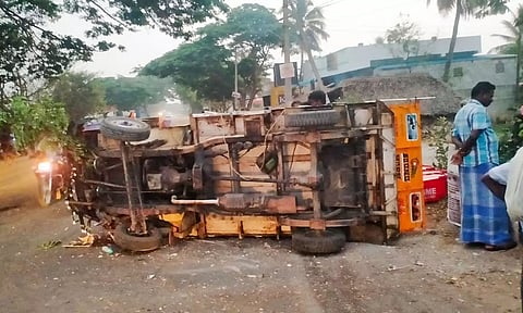 சாலையில் கவிழ்ந்து கிடக்கும் லாரி.