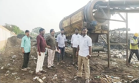 குப்பை கிடங்கில் அதிகாரிகள் ஆய்வு மேற்கொண்ட காட்சி.