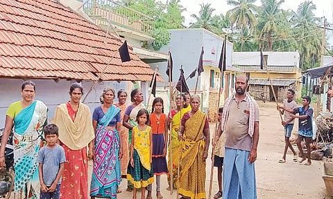 கருப்பு கொடியுடன் போராட்டத்தில் ஈடுபட்ட கிராம மக்கள்.