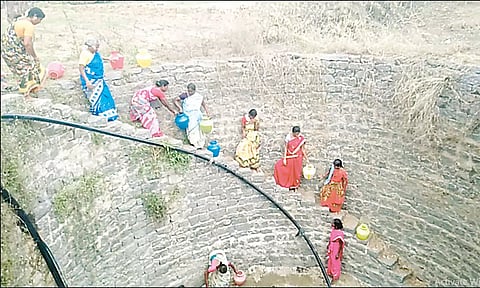 கிணற்றுக்குள் இறங்கி பெண்கள் தண்ணீர் எடுக்கும் காட்சியை படத்தில் காணலாம்.