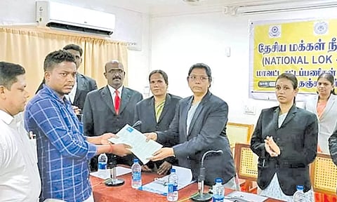 தேசிய மக்கள் நீதிமன்றத்தில் தீர்வு பெற்றவருக்கு தீர்வுக்கான சான்றிதழை வழங்குகிறார் முதன்மை மாவட்ட நீதிபதி ஜெசிந்தா மார்ட்டின். 