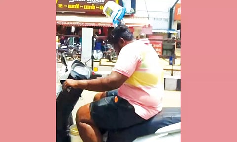 வெயிலை சமாளிக்க தலையில் தண்ணீர் ஊற்றியப்படி ஸ்கூட்டரை ஓட்டிய வாலிபர்- அபராதம் விதித்து எச்சரித்த போலீசார்