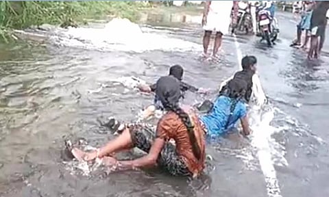 ஆறாக ஓடிய நீரில் குளித்து மகிழ்ந்த சிறுவர்களையும் படத்தில் காணலாம்.