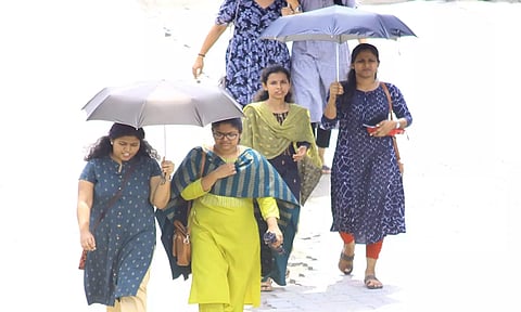 பாளை முருகன்குறிச்சி- திருவனந்தபுரம் சாலையில் குடை பிடித்து செல்லும் பெண்களை படத்தில் காணலாம்.