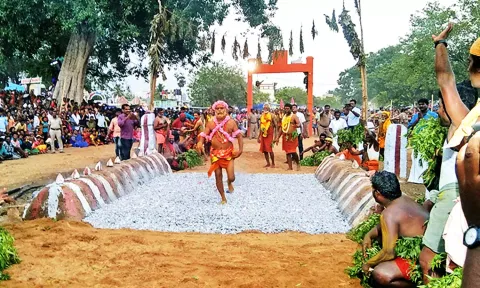 திரவுபதி அம்மன் கோவிலில் பூசாரி மாரிமுத்து பூக்குழி இறங்கிய காட்சி.