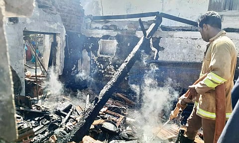 வீட்டில் பற்றி எரிந்த தீயை அணைக்கும் பணியில் ஈடுபட்ட தீயணைப்பு துறையினர்.