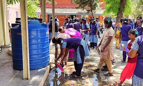 சின்டெக்ஸ் டேங்குகள் மேல் மூடிகள் உடைந்து இருப்பதால் குடிநீரில் அசுத்தம் இருப்பதையும், அதனை கவனிக்காத மாணவிகள் பாட்டிலில் தண்ணீரை நிரப்புவதையும் படத்தில் காணலாம்.