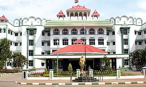 கிராம உதவியாளரை பணிநீக்கம் செய்வதற்கான நோட்டீஸ் அனுப்பியதற்கு தடை- மாவட்ட கலெக்டர் பதிலளிக்க மதுரை ஐகோர்ட் உத்தரவு