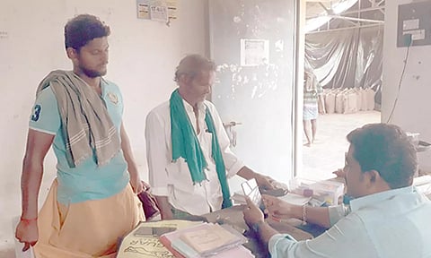 கொள்முதல் நிலையங்களில் பயோ மெட்ரிக் கருவியில் விரல் ரேகையை பதிவு செய்யும் விவசாயிகள்.