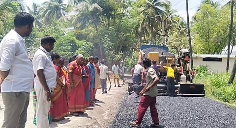 தார் சாலை அமைக்கும் பணியை பேரூராட்சி தலைவர் ஆய்வு செய்த காட்சி.