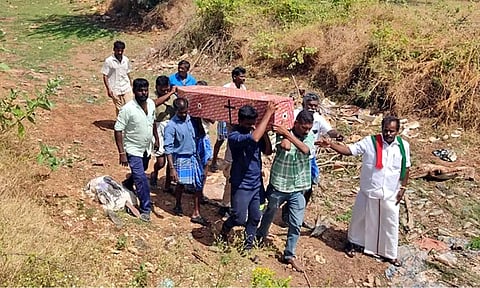 இறந்த விஜயகுமார் உடலை ஓடை கரை ஓரம் சுமந்தவாறு உறவினர்கள் எடுத்து சென்ற காட்சி.