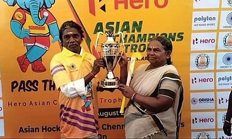 ஹாக்கி போட்டிக்கான கோப்பையுடன் போஸ் கொடுக்கும் பாகன் தம்பதியினரை படத்தில் காணலாம்.