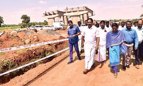 சாலை அமைக்கும் பணிகளை அமைச்சர் மூர்த்தி ஆய்வு செய்தார். அருகில் கலெக்டர் சங்கீதா உள்ளார்.