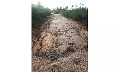 குண்டும் குழியுமாக உள்ள சாலையை படத்தில் காணலாம்.
