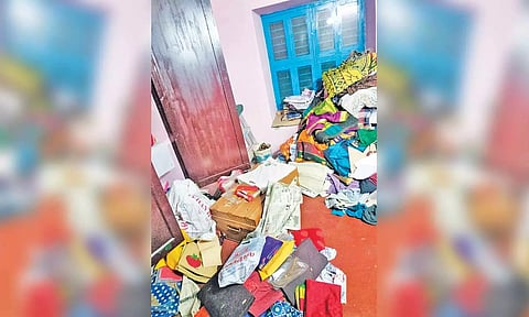 கொள்ளை நடந்த வீட்டில் பொருட்கள் சிதறி கிடக்கிறது.