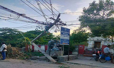 லாரி மோதி முறிந்த மின்கம்பத்தை படத்தில் காணலாம்.