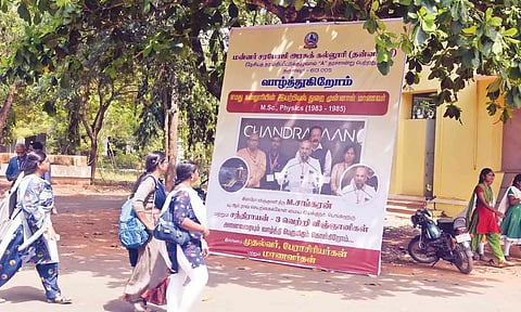 இஸ்ரோ விஞ்ஞானி சங்கரனை பாராட்டி வைக்கப்பட்டுள்ள பிளக்ஸ் போர்டை பார்வையிடும் மாணவிகள்.