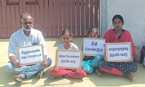 வீட்டின் முன் தர்ணா செய்த தொழிலாளி.