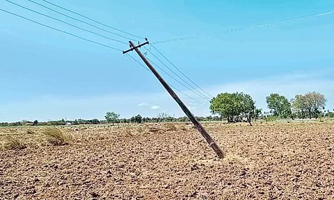 சாய்ந்த நிலையில் உள்ள மின்கம்பங்களை சீரமைக்க வேண்டும்