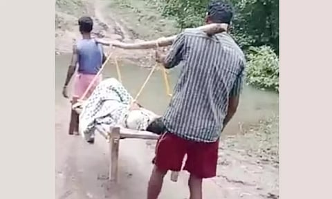கர்ப்பிணியை ஆஸ்பத்திரிக்கு சுமந்து சென்ற காட்சி.