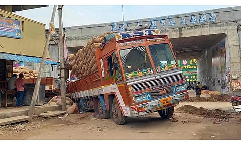 சாலையோர பள்ளத்தில் சிக்கிய லாரியை படத்தில் காணலாம்.