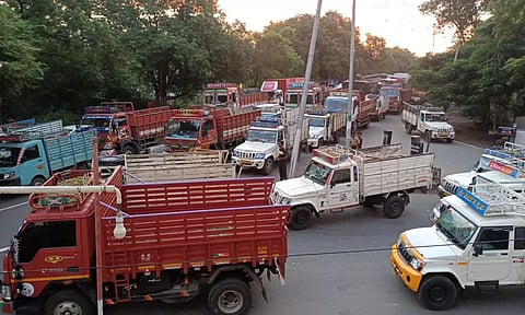 பண்ணாரி சோதனைச்சாவடியில் நீண்ட வரிசையில் வாகனங்கள் நிறுத்தப்பட்டுள்ளதை காணலாம். 