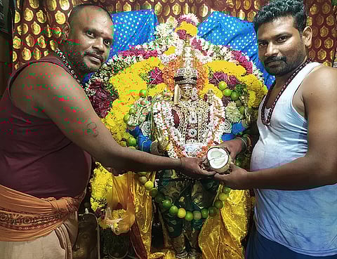 இரட்டை தேங்காயை அம்மனுக்கு பூசாரிகள் காண்பிக்கும் காட்சி.