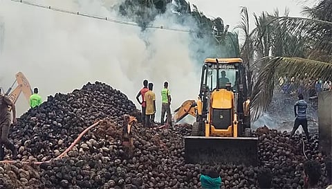 தேங்காய் குடோனில் தீ எரிந்ததை தீயணைப்பு வீரர்கள் தீயைஅணைப்பதையும் எடுத்த படம்.
