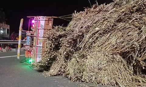 சாலையில் கவிழ்ந்து கிடக்கும் லாரியை படத்தில் காணலாம்.