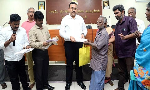 கூட்டத்தில் கலெக்டர் ரவிச்சந்திரன், பயனாளி ஒருவருக்கு நலத்திட்ட உதவிகள் வழங்கிய காட்சி.