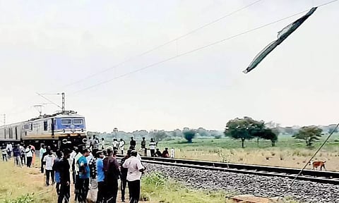 உயர் அழுத்த மின்கம்பியில் சிக்கிய சேலையையும், அதில் இருந்து சில அடி தூரத்தில் ரெயில் நிறுத்தப்பட்டதையும் காணலாம்.