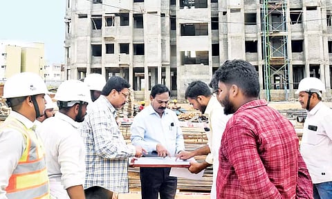 அடுக்குமாடி குடியிருப்புகள் கட்டும் பணிகளை ஆய்வு செய்த அதிகாரி.
