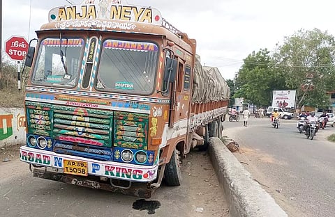 சாலை தடுப்புச்சுவரில் மோதி நிற்கும் வடமாநில லாரி.