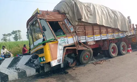 பண்ருட்டி அருகே சாலையின் நடுவே இருந்த தடுப்பு கட்டையில் அரிசி ஏற்றி வந்த லாரிமோதி நின்ற காட்சி.