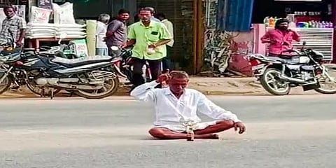 நடுரோட்டில் அமர்ந்து மதுகுடித்தவரை படத்தில் காணலாம்.
