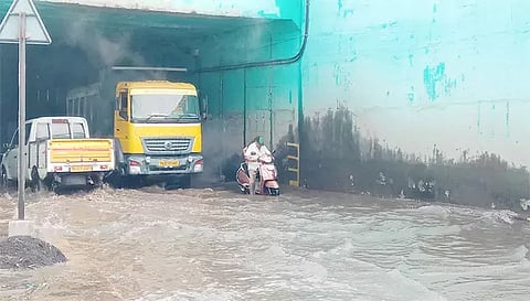 குளம்போல் தேங்கி நிற்கும் மழைநீரில் ஊர்ந்து செல்லும் வாகனங்கள்.