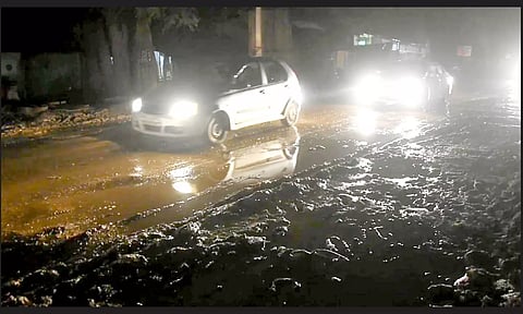 குண்டும் குழியுமான சாலையில் வாகனங்கள் செல்வதை காணலாம்.