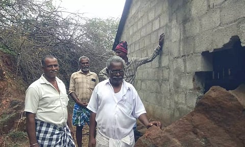 பாறை உருண்டு சேதமடைந்துள்ள வீட்டை படத்தில் காணலாம்.