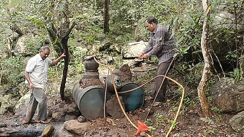 பேரல்களில் இருந்த சாராய ஊறல்கள் மற்றும் அடுப்புகளை உடைத்தெரியும் போலீசாரை படத்தில் காணலாம்.