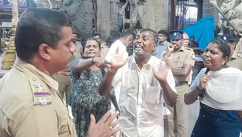 ஸ்ரீவில்லிபுத்தூர் ஆண்டாள் கோவில் வளாகத்தில் தீக்கு ளிக்க முயன்று போலீசாருடன் வாக்குவாதத்தில் ஈடுபட்ட ஒப்பந்ததாரர் ராமர் மற்றும் அவரது சகோதரி.
