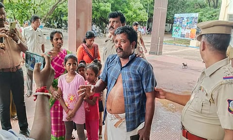 தீக்குளிக்க முயன்ற விவசாயி குடும்பத்தை படத்தில் காணலாம்.