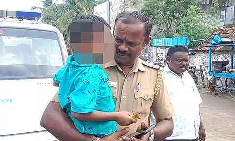 அழுது கொண்டிருந்த குழந்தையை மீட்டு சமாதானப் படுத்தும் சப்-இன்ஸ்பெக்டரை படத்தில் காணலாம்.