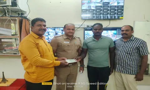 போலீசார் மணிபர்சை உரியவரிடம் ஒப்படைத்த காட்சி.