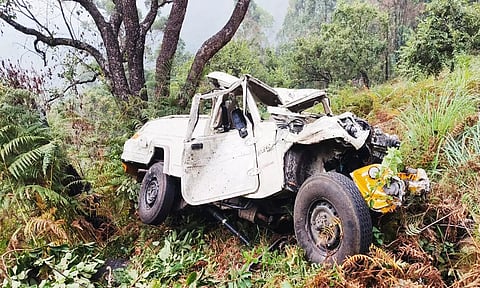 கொடைக்கானலில் பள்ளத்தில் கவிழ்ந்து கிடக்கும் வேன்.