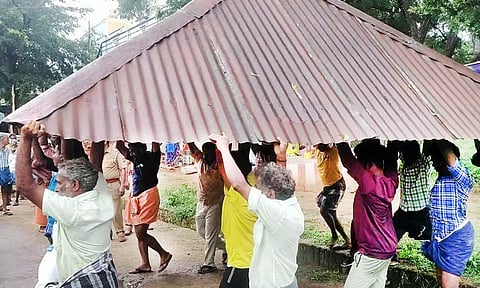 கோவில் மேற்கூரையை அகற்றிச் சென்ற ஊழியர்கள்.